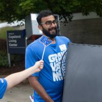 Gentleman getting asked questions for social media while carrying small fridge